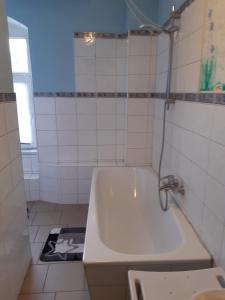 a white bathroom with a tub and a sink at Ferienwohnung Petersbrunnen in Zaschwitz