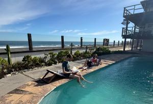 皮奇勒姆Sudeste Hostel的两个人坐在海边的游泳池旁 更多14张照片