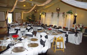 a banquet hall with white tables and chairs and flowers at Waterton Lakes Lodge Resort in Waterton Park
