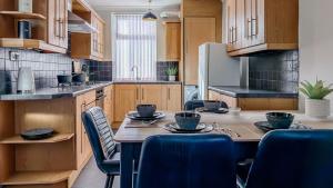 eine Küche mit Tisch und Stühlen und einem Kühlschrank in der Unterkunft Hexthorpe House - By Sigma Stays in Doncaster + 25 Fotos