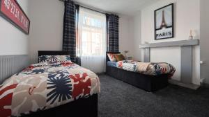 ein Schlafzimmer mit zwei Betten und einem Kamin in der Unterkunft Hexthorpe House - By Sigma Stays in Doncaster