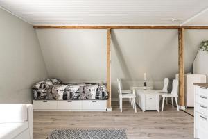 a bedroom with a bed and a table and chairs at Lovely studio in wooden house, private bath&parking in Turku