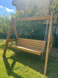 a wooden swing sitting in the grass in a yard at Casa Lauda in Pillichsdorf in Pillichsdorf