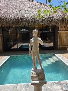 a statue of a man standing next to a swimming pool at Fm Luxury villa viscaya Mini Playa y piscina privada in Nilo