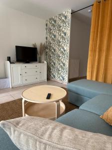 a living room with a blue couch and a table at Escapade Jurassienne-Terrasse & Sérénité in Lons-le-Saunier
