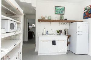 a white kitchen with a sink and a microwave at Little Noone in Jackson +31 photos