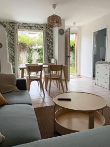 a living room with a couch and a table at Escapade Jurassienne-Terrasse & Sérénité in Lons-le-Saunier