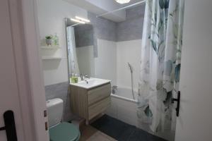a bathroom with a sink and a toilet and a tub at Escapade Jurassienne-Terrasse & Sérénité in Lons-le-Saunier