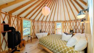 a bedroom with a bed and a tub in a yurt at Desolation Hotel Hope Valley in Markleeville