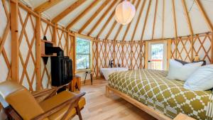 a bedroom with a bed and a tub in a yurt at Desolation Hotel Hope Valley in Markleeville