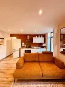 a living room with a couch and a kitchen at Chez Isa et Bruno chambres in Eymet