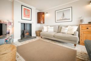 a living room with a couch and a fireplace at Penrose in Downderry