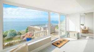 a room with a large window with a view of the ocean at Penrose in Downderry