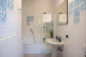 a white bathroom with a sink and a shower at Villa d'Este - Historic City Villa with WiFi & Air Conditioning in Ferrara