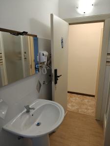a bathroom with a white sink and a mirror at Tidale Host house B&B in Alghero