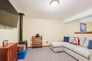 a living room with a couch and a flat screen tv at Ayers Farm Cottage in Stowe