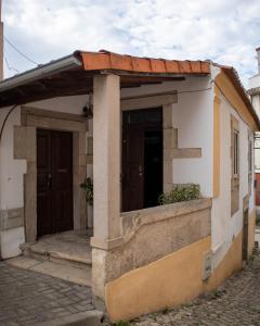 a small house with a porch and two doors at Casa de Santa Luzia in Mirandela
