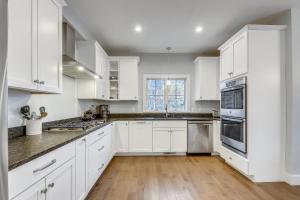 a white kitchen with white cabinets and a wooden floor at Benjamin Trail in Stowe