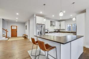 a kitchen with white cabinets and a black counter top at Benjamin Trail in Stowe +28 photos