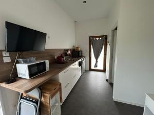 a kitchen with a counter with a microwave and a television at Studio Lapalisse chez Pierre et Delphine in Lapalisse
