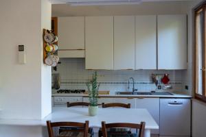 a kitchen with white cabinets and a table with a potted plant at Villa d'Este - Historic City Villa with WiFi & Air Conditioning in Ferrara +21 photos