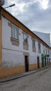 a white building with windows on the side of a street at Casa de Santa Luzia in Mirandela