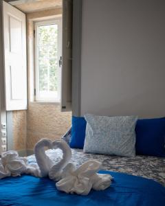 two swans made out of towels on a bed at Casa de Santa Luzia in Mirandela