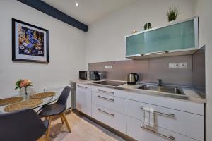 a kitchen with a sink and a table at Apartment Mostecka in Prague