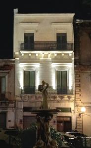 a building with a fountain in front of a building at La Dimora degli Scrittori in Giarre