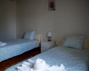 two beds in a room with towels on them at Casa de Santa Luzia in Mirandela +10 photos