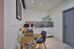 a small kitchen with a glass table and chairs at Apartment Mostecka in Prague