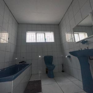 a bathroom with a tub and a toilet and a sink at MBT Lodge in Polokwane