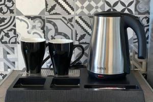 una cafetera y dos tazas sentadas en un mostrador en 1 Bed Apt - Sleeps 2 - Free Parking - Sea View, en Masouri