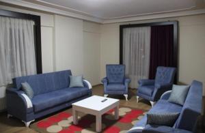 a living room with blue couches and chairs and a table at butik konaklama in Aksaray