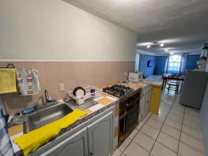 une cuisine avec un évier et une cuisinière dans l'établissement Casa cerca de Plaza de Toros de Apizaco y del Centro Deportivo de Alto Rendimiento, à San Dionisio Yauhquemehcan 6 autres photos