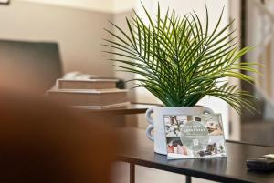 a potted plant sitting on a table with a mug at Chic 5-bedroom House in Basingstoke with Parking by PureStay in Basingstoke