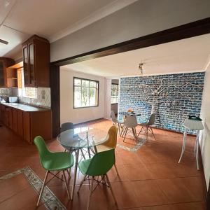 a kitchen and dining room with a glass table and chairs at MBT Lodge in Polokwane