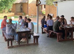 a group of people sitting at tables in a restaurant at Rangers Airport Lodge in Benoni