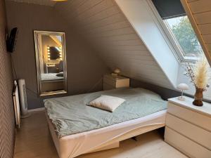 a small bedroom with a bed and a mirror at Villa Malena in Fensmark