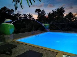 a swimming pool at night with a water fountain at Laila Places at Lanta in Ko Lanta