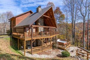 une grande cabane en rondins dans les bois avec une terrasse dans l'établissement Ambleside, à Vilas