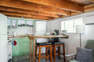 eine Küche mit grünen Schränken und einer Theke mit Hockern in der Unterkunft Galloway Cottage- Bikes & Firepit in Springfield