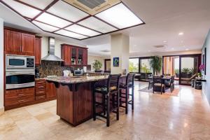 een grote keuken met een groot eiland met barkrukken bij Beachfront, Sunset, & Ocean Views With Gas Grill in Tamarindo