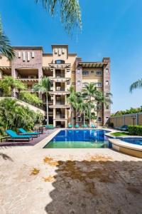 een gebouw met een zwembad voor een gebouw bij Beachfront, Sunset, & Ocean Views With Gas Grill in Tamarindo