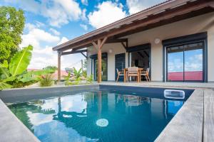 una piscina frente a una casa en Villa Indonésie-piscine privé au centre de l'île, en Les Abymes