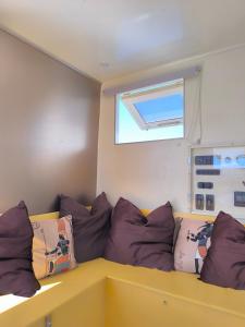 a room with a couch with pillows and a window at Kawaida - Hébergement insolite - Yaliyo in Saint-Pierre +20 photos