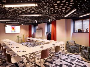 a conference room with tables and chairs and a ceiling at Mama Shelter Paris La Défense in Puteaux