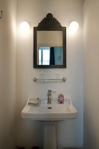 une salle de bain avec un lavabo et un miroir dans l'établissement La Joséphine, à Cosne Cours sur Loire