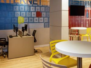 a room with a white table and yellow chairs at ibis budget Maceió Pajuçara in Maceió