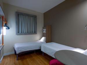 マセイオにあるibis budget Maceió Pajuçaraのベッド2台とテーブルがあるホテルの部屋